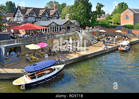 Looking down from above at electric boat hire & pub business diverse group of people hot summer day at River Thames Wallingford Oxfordshire England UK Stock Photo