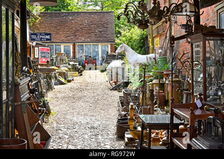 Display of historical antiques  collectables & bric a brac in dealer courtyard & showrooms with Green Shield sign at Hungerford Berkshire England UK Stock Photo