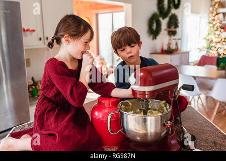 Two children in the kitchen making a cake Stock Photo