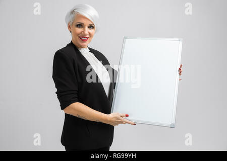 young girl with a magnetic Board in her hands stands isolated on a light background Stock Photo