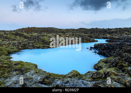 Dramatic landscape of a beautiful volcanic terrain with black volcanic rocks and turquoise water at Blue Lagoon near Grindavik in Reykjanes peninsula  Stock Photo