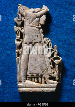 Standing male figure: Nimrud Ivory from Room SW37 Fort Shalmaneser within the Assyrian city of Nimrud, Iraq, photographed in the Iraq Museum, Baghdad. Stock Photo