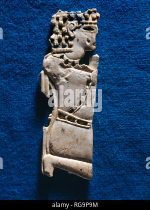 Kneeling male figure: Nimrud Ivory from Room SW37 Fort Shalmaneser within the Assyrian city of Nimrud, Iraq, photographed in the Iraq Museum, Baghdad. Stock Photo
