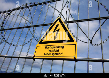 Signpost  and fence at an open space solar photovoltaic plant, Germany, Europe Stock Photo