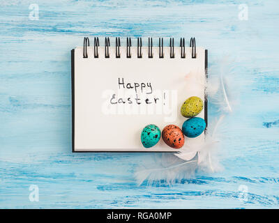Easter eggs painted in bright colors on a blue background. Top view, close-up, isolated. Happy Easter. Preparation for the holiday Stock Photo