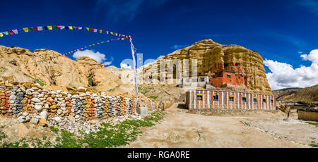 Panoramic view on the local monastery Nifuk Gompa, located below a rock cliff, the monastery school and a Mani wall with colorful prayer flags Stock Photo