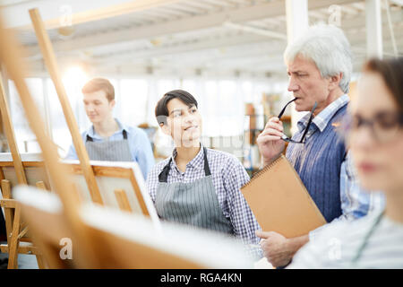 Portrait of smiling art student looking at teacher during class in workshop studio, copy space Stock Photo