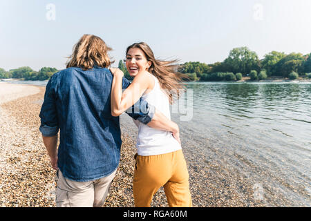 Happy young couple in love walking at the riverside Stock Photo