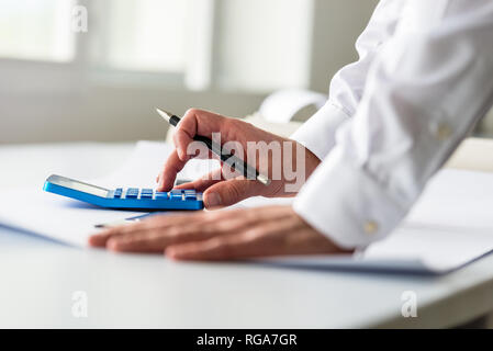 Closeup of engineer or architect working on a project using a calculator. Stock Photo