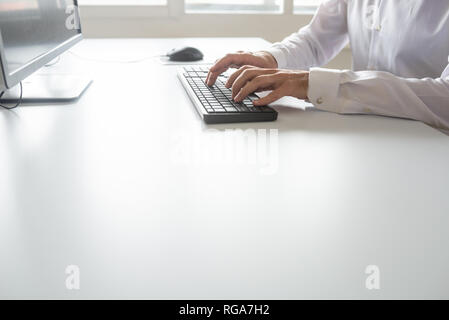Programmer or student sitting at his office desk working using computer. Stock Photo