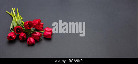 Valentines day concept. Red tulips bouquet on dark gray background, banner, copy space Stock Photo