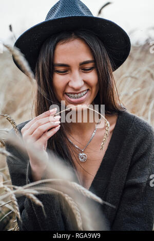 Portrait of laughing young woman dressed in black in a corn field Stock Photo