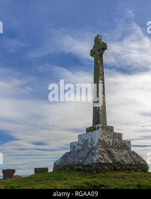 Memorial cross in the church yard of the site containing the Kirkmadrine Stones in Dumfries and Galloway, Scotland, UK set against a blue sky with whi Stock Photo