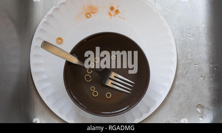Dirty dishes left in a stainless steel sink. Stock Photo