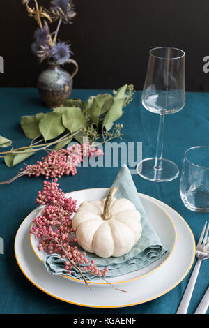 Autumnal table decoration with white decorative gourd and pink peppercorns Stock Photo