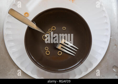 Dirty dishes left in a stainless steel sink. Stock Photo