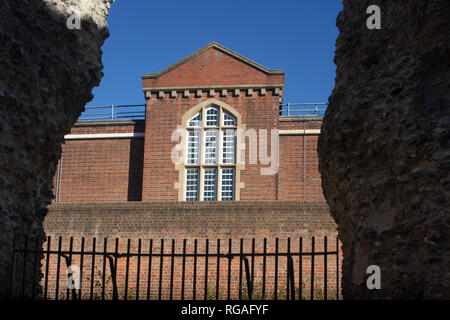 The main Victorian building of Reading Prison viewed through the ruins of Reading Abbey, Berkshire Stock Photo