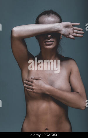 Nude woman covering her breast and eyes with hands Stock Photo - Alamy