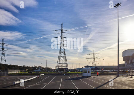 Electricity plyons tower above the Isle of Man vehicle check in kiosk next to the nuclear power station at Heysham Stock Photo