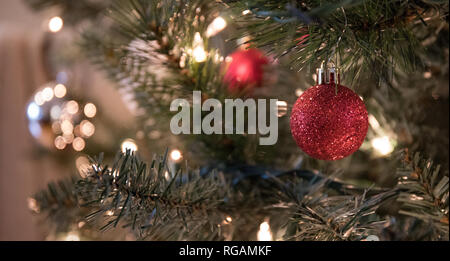 Close up photo of Christmas ball decorations hanging on the pine branches of a Christmas tree. Stock Photo