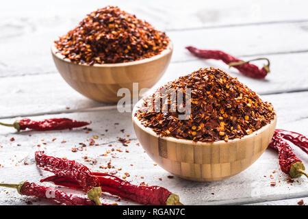 Dried and crushed chili peppers in wooden bowles. Stock Photo