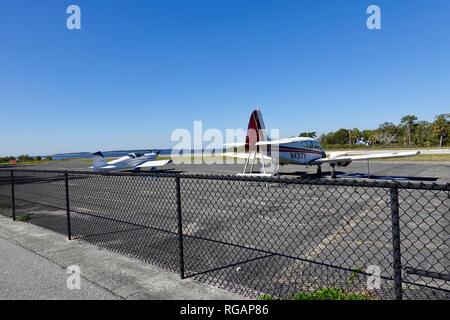 Piper PA 23 160 Apache damaged aircraft and small, single engine float plane parked at the end of the island airport runway, Cedar Key, FL, USA. Stock Photo