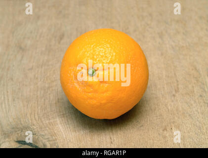Still-life with ripe orange on brown wooden surface front view horizontal closeup Stock Photo