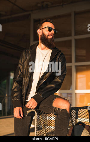 Stylish bearded young man outdoors looking sideways Stock Photo