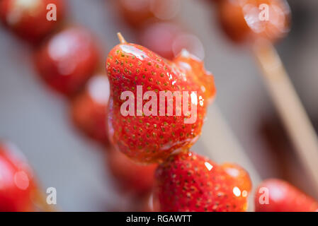 Tanghulu traditional Chinese hard caramel coated strawberry skewers close-up also called bing tanghulu candied hawthorn sticks Stock Photo