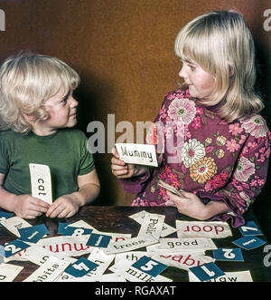An older girl teaching her younger brother to read with the use of flash cards. Stock Photo