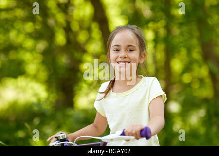 happy little girl with bicycle in summer Stock Photo