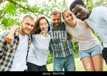 Happy multicultural group of young people or friends in nature Stock Photo