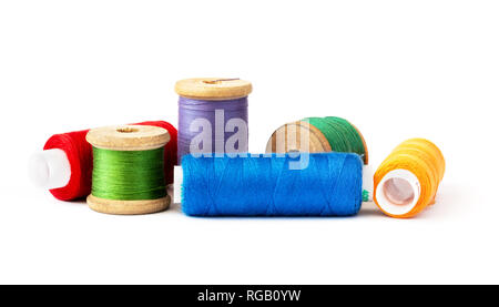 Multi-colored threads on wooden and plastic spools, on a white background. Stock Photo