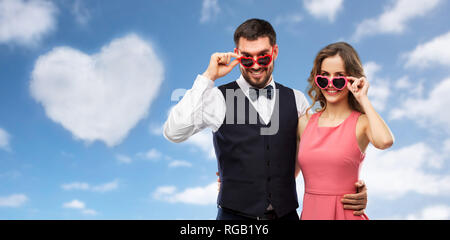 happy couple in heart-shaped sunglasses Stock Photo
