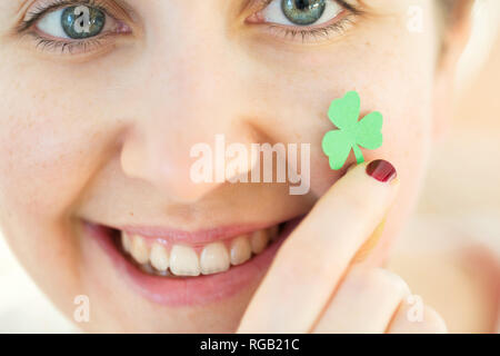 close up of happy young woman face with shamrock Stock Photo