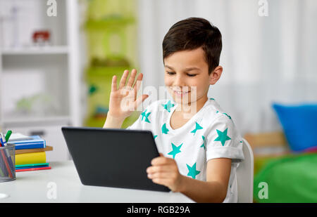 boy with tablet computer having video chat at home Stock Photo