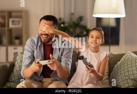 father and daughter playing video game at home Stock Photo