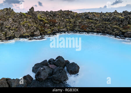 Dramatic landscape of a beautiful volcanic terrain with black volcanic rocks and turquoise water at Blue Lagoon near Grindavik in Reykjanes peninsula  Stock Photo