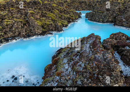 Dramatic landscape of a beautiful volcanic terrain with black volcanic rocks and turquoise water at Blue Lagoon near Grindavik in Reykjanes peninsula  Stock Photo