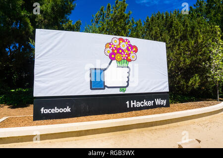 May 8, 2018 Menlo Park / CA / USA - The Facebook Like Button sign holding a bouquet of flowers (celebrating Mother's Day) located at the entrance to t Stock Photo
