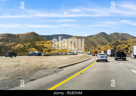 June 10, 2018 Los Angeles / CA / USA - Driving on the interstate through mountains covered in green shrubs and dry grass Stock Photo