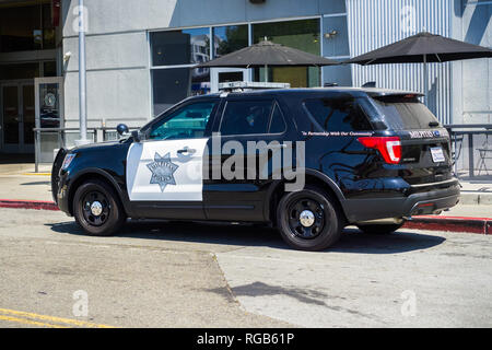 August 1, 2018 Milpitas / CA / USA - Police car stopped on the side of the road in front of a restaurant; Great Mall, south San Francisco bay area Stock Photo