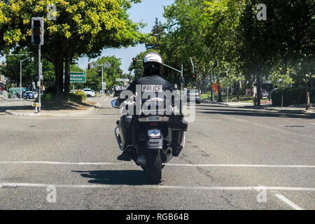August 2, 2018 Mountain View / CA / USA - A motorcycle police officer on patrol on the streets of south San Francisco bay area; back view Stock Photo