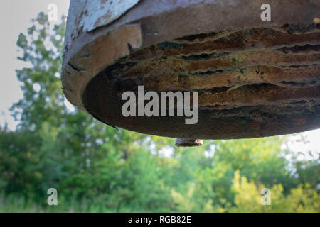 A rusty metal sewer vent in an open field on a sunny day. Stock Photo