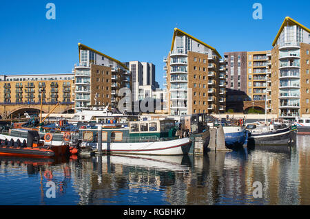 Boats moored in Limehouse Basin, East London UK, with modern apartment buildings behind Stock Photo