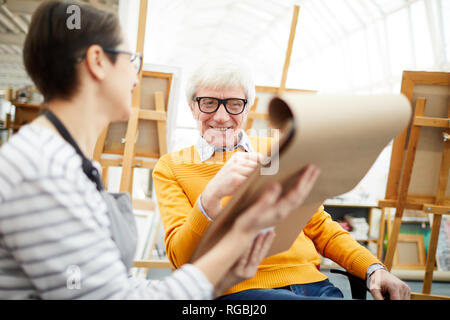 Portrait of senior art teacher working with student and smiling happily during sketch session, copy space Stock Photo