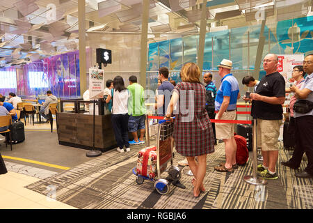 SINGAPORE - CIRCA AUGUST, 2016: people queue at Singapore Changi Airport. Changi Airport is one of the largest transportation hubs in Southeast Asia. Stock Photo