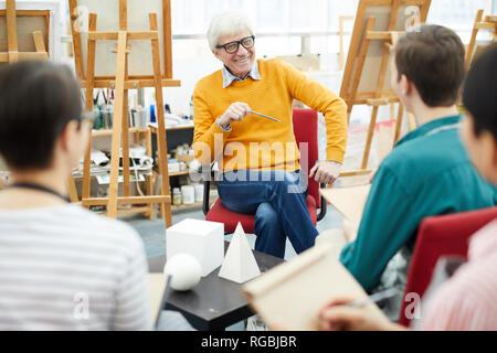 Portrait of group of art students listening to teacher during sketching session in college Stock Photo
