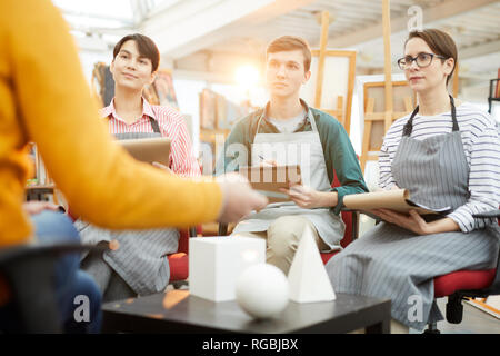 Portrait of group of art students listening to teacher during sketching session in college Stock Photo