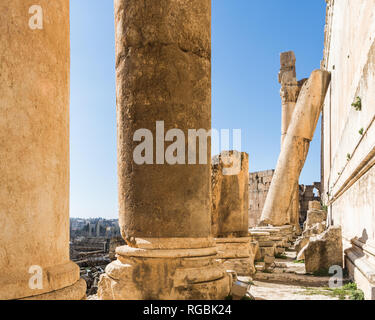 Destroyed column leaning against Temple of Bacchus' wall, Heliopolis Roman ruins, Baalbek, Lebanon Stock Photo